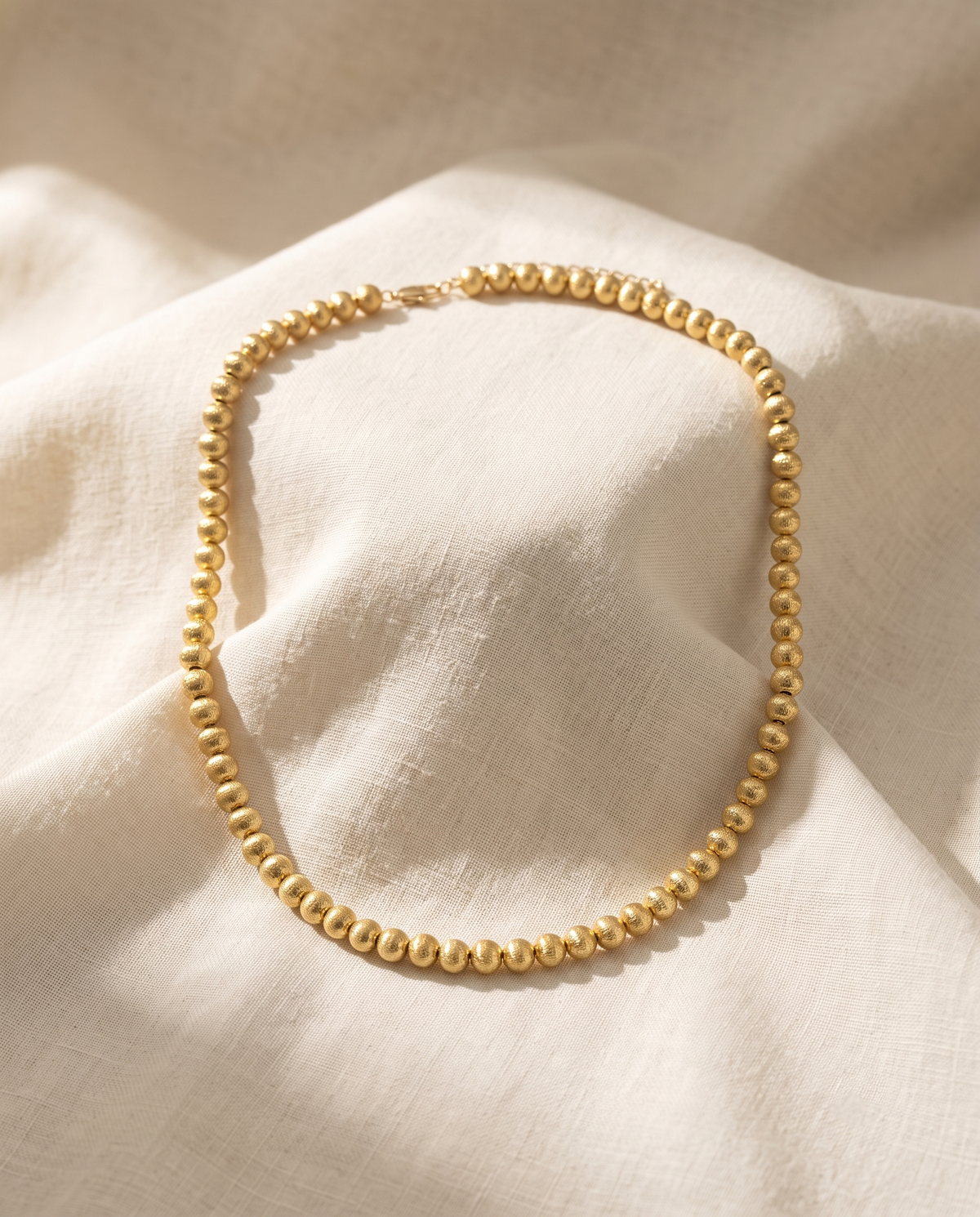 Brushed gold bead strand necklace